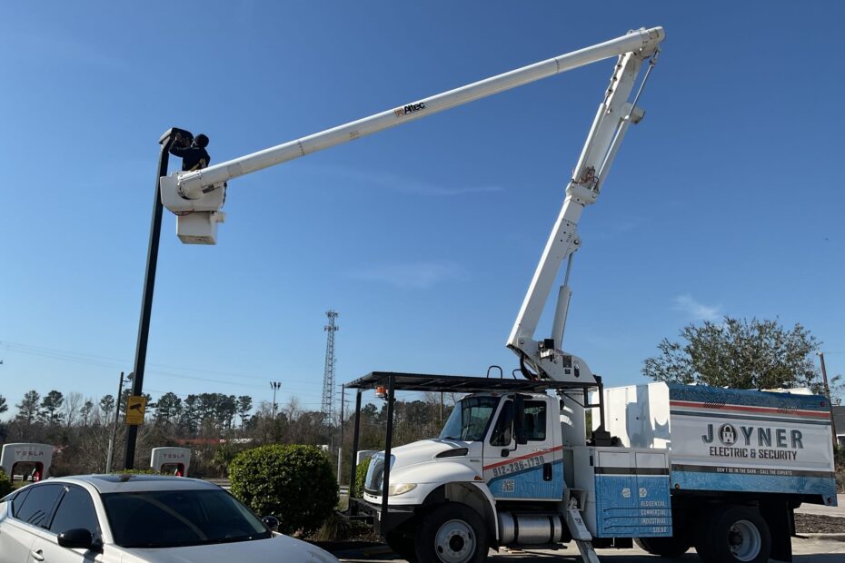 man in bucket truck performing maintenance on pole light.